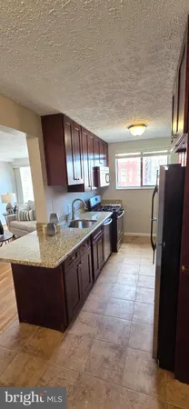 a large kitchen with kitchen island granite countertop a sink and a refrigerator