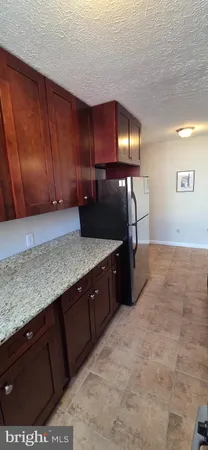 a kitchen with granite countertop wooden cabinets and a sink