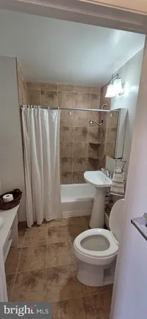 a white toilet sitting next to a bath tub