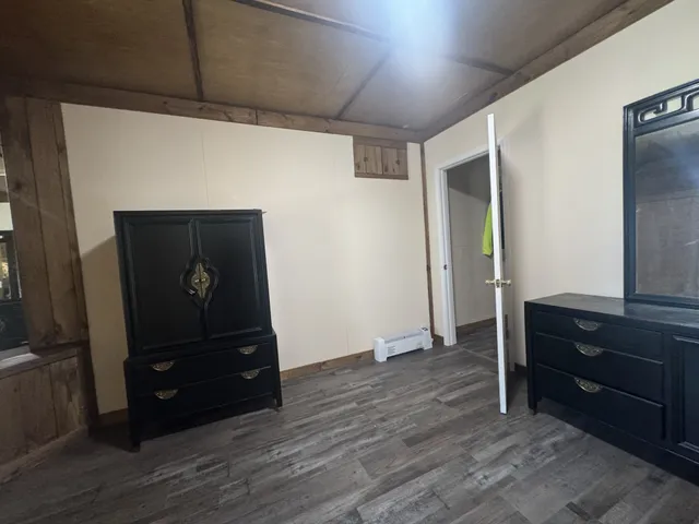 a view of a wooden deck with a bench and trees