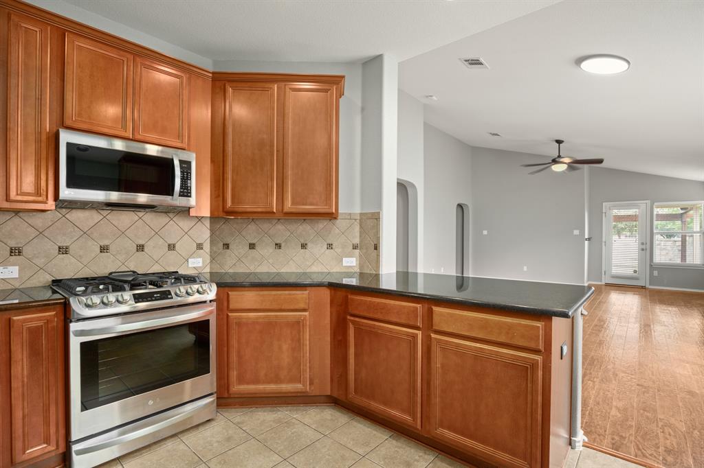 14012 Marathon Road Austin, TX 78717 - Photo 5 of 13 a kitchen with granite countertop a stove top oven microwave and cabinets