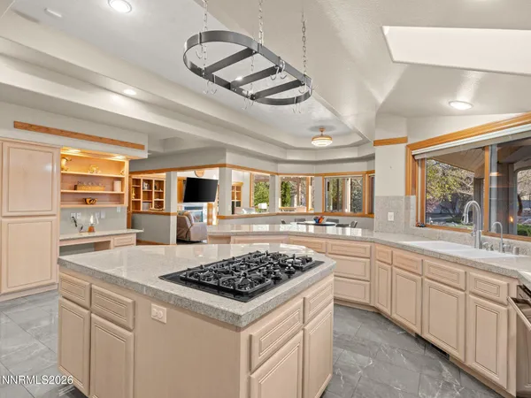 a kitchen with a stove a sink dishwasher and white cabinets with wooden floor