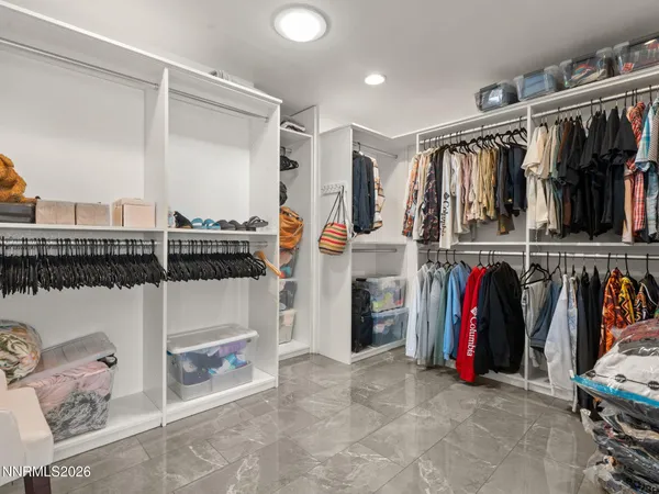 a view of walk in closet with clothes and shoes