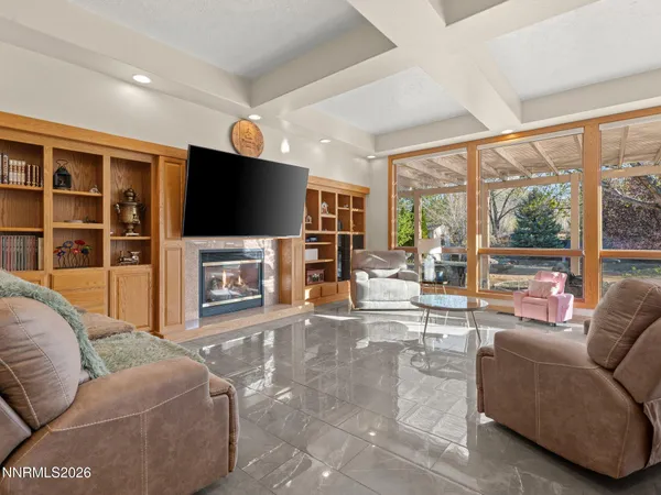 a living room with furniture a flat screen tv and a floor to ceiling window