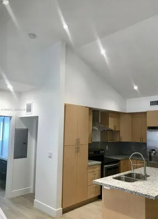 a kitchen with granite countertop a sink and a refrigerator
