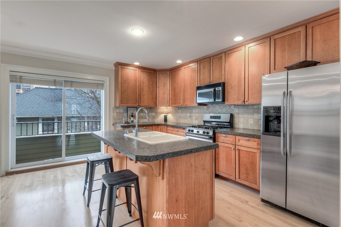 1940 9th Avenue West Seattle, WA 98119 - Photo 6 of 25 a kitchen with stainless steel appliances granite countertop a stove refrigerator sink and cabinets