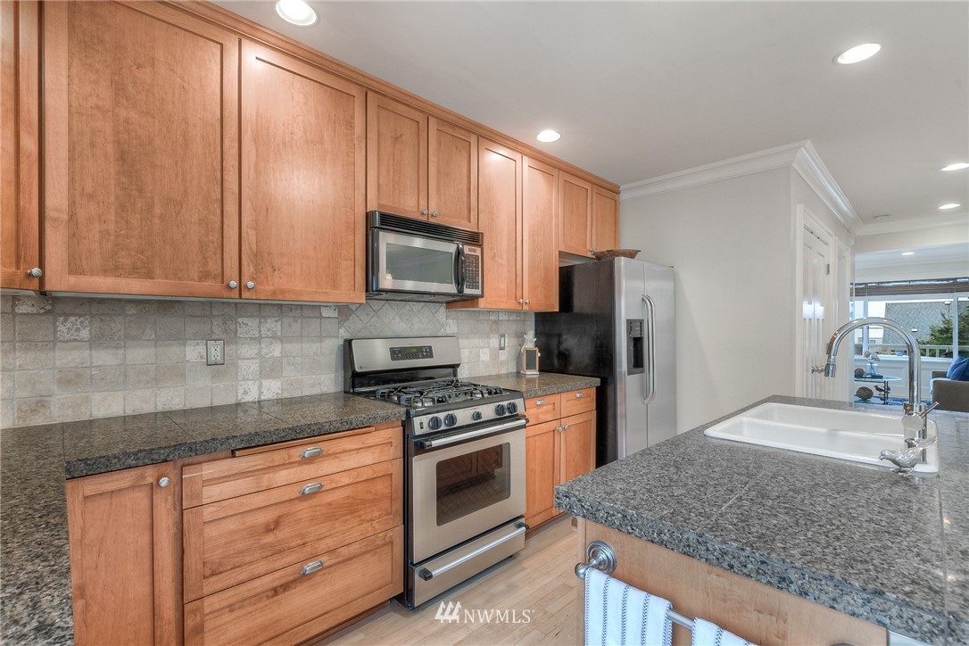 1940 9th Avenue West Seattle, WA 98119 - Photo 7 of 25 a kitchen with stainless steel appliances granite countertop a stove a sink and a microwave