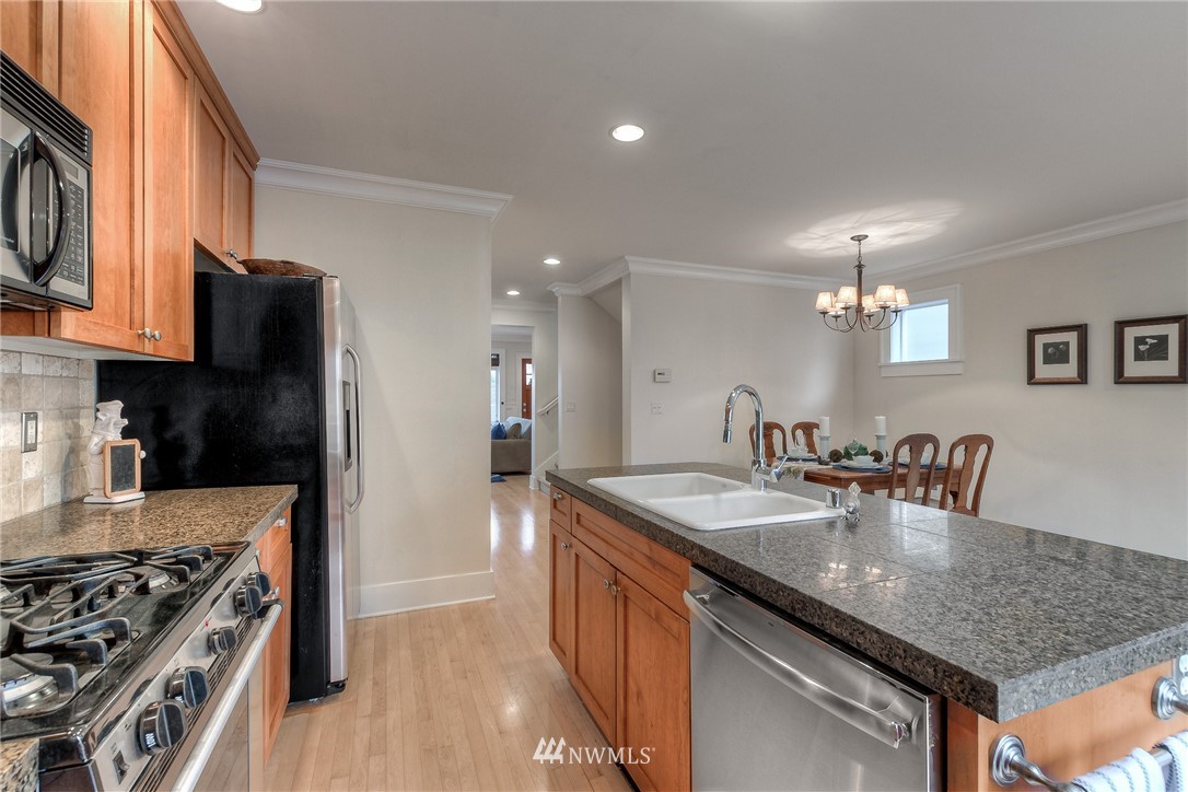 1940 9th Avenue West Seattle, WA 98119 - Photo 8 of 25 a kitchen with stainless steel appliances granite countertop a sink a stove and a refrigerator