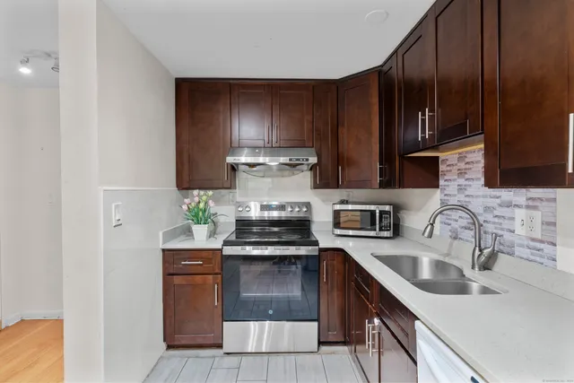 a kitchen with stainless steel appliances granite countertop a sink stove and cabinets
