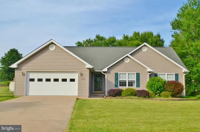 a view of a house with a yard and potted plants