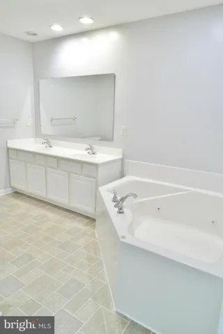 a bathroom with a tub a sink and a shower