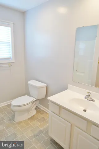 a bathroom with a sink a toilet and a window