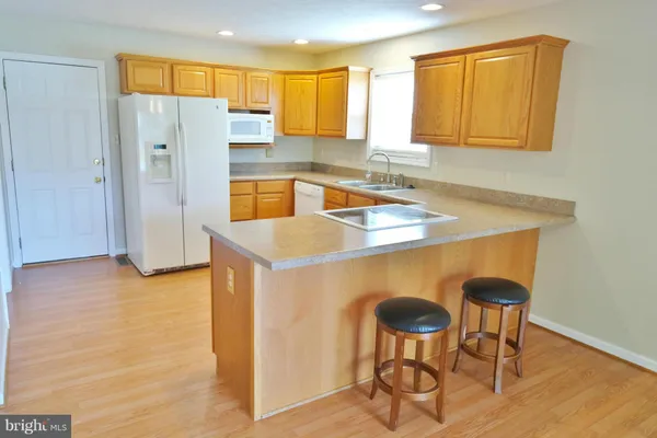 a kitchen with stainless steel appliances granite countertop a sink refrigerator and cabinets