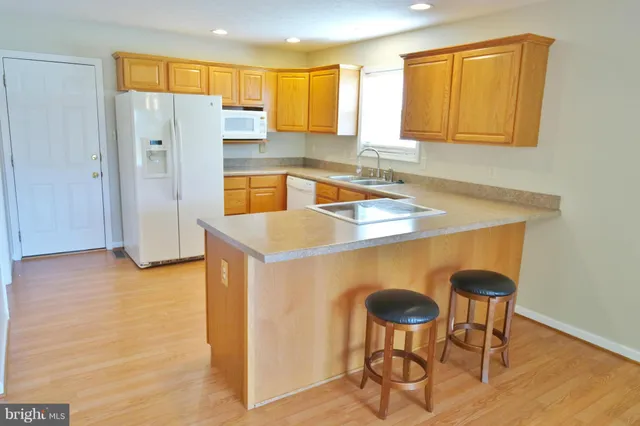 a kitchen with stainless steel appliances granite countertop a sink refrigerator and cabinets