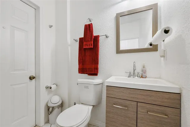 a bathroom with a toilet sink vanity and mirror