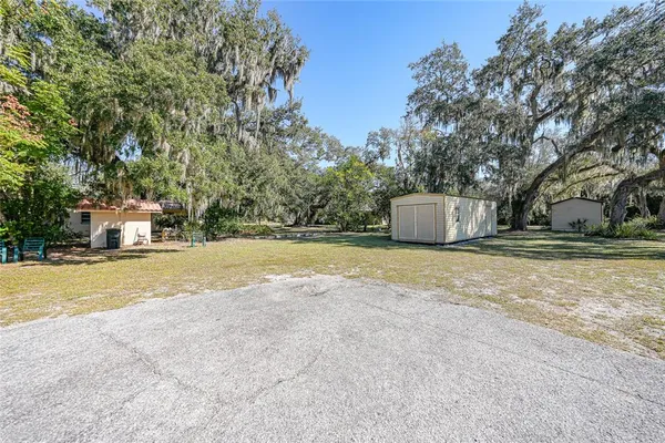 a view of a house with a yard and a large tree