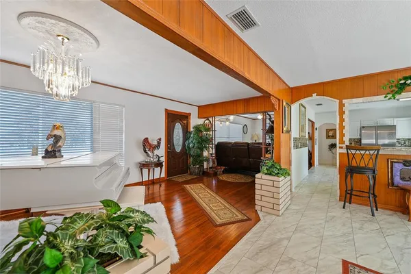a living room with furniture a fireplace and a chandelier