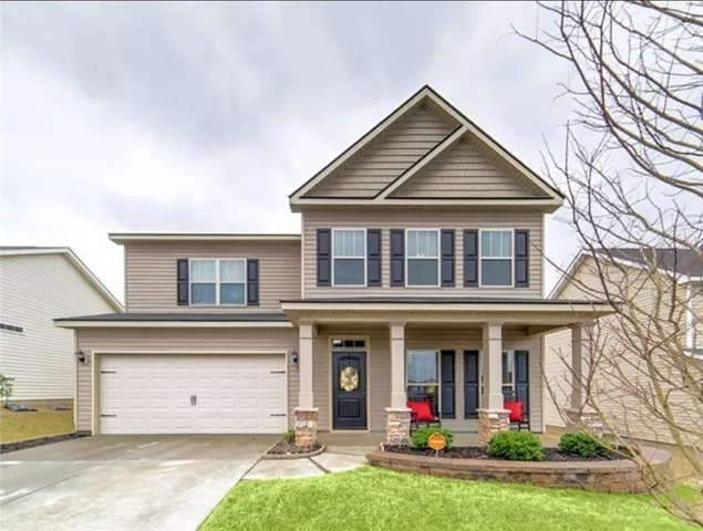 a front view of a house with a yard and garage