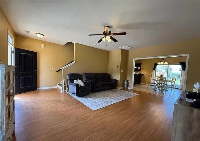 a view of a dining room with furniture a chandelier and wooden floor