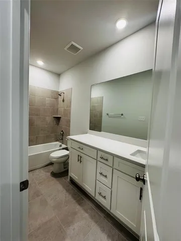 a bathroom with a granite countertop sink a toilet and bathtub