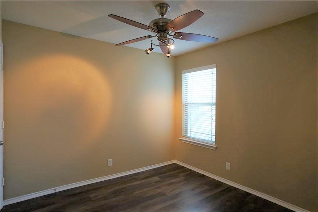 201 Edwin Kyle, TX 78640 - Photo 16 of 21 Neutral-toned room featuring a window with horizontal blinds, wood-finish flooring, and a ceiling fan with integrated lighting