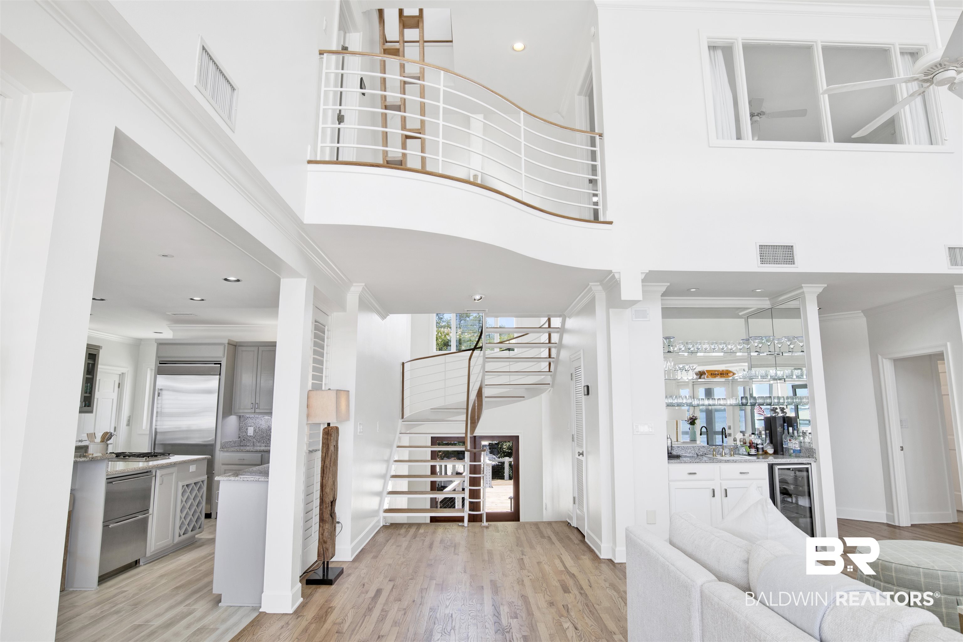 33400 River Road Orange Beach, AL 36561 - Photo 23 of 72 Entryway featuring beverage cooler, ornate columns, light wood-type flooring, and a high ceiling
