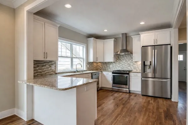 a kitchen with kitchen island granite countertop appliances cabinets and a sink