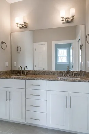 a bathroom with a granite countertop sink and a mirror