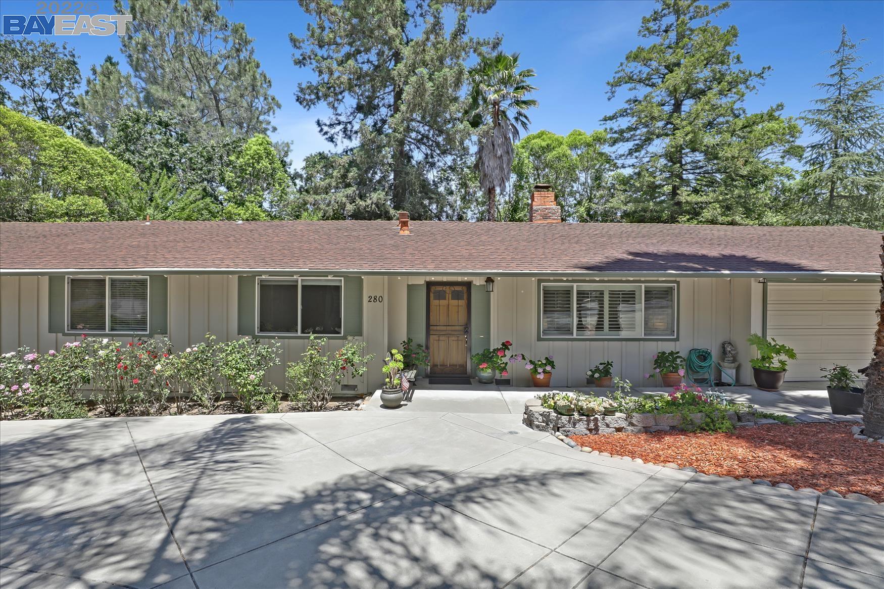 a front view of a house with a yard and potted plants
