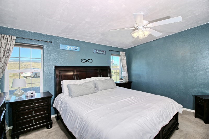 796 Siminoe Road Whitewater, CO 81527 - Photo 12 of 37 a bedroom with a bed and wooden floor