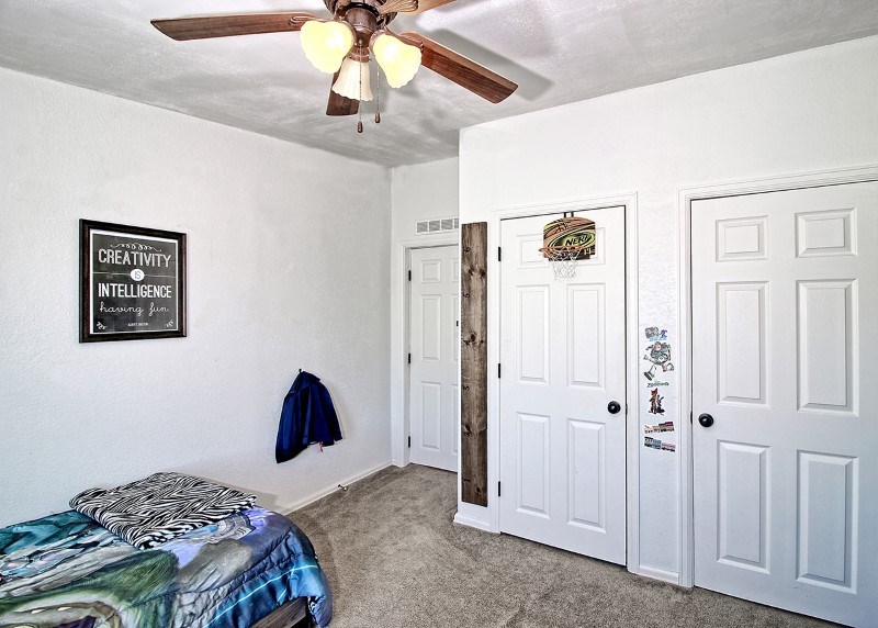 796 Siminoe Road Whitewater, CO 81527 - Photo 16 of 37 a bedroom with a bed and a chandelier