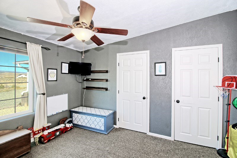 796 Siminoe Road Whitewater, CO 81527 - Photo 18 of 37 a bedroom with a bed a flat screen tv and a window
