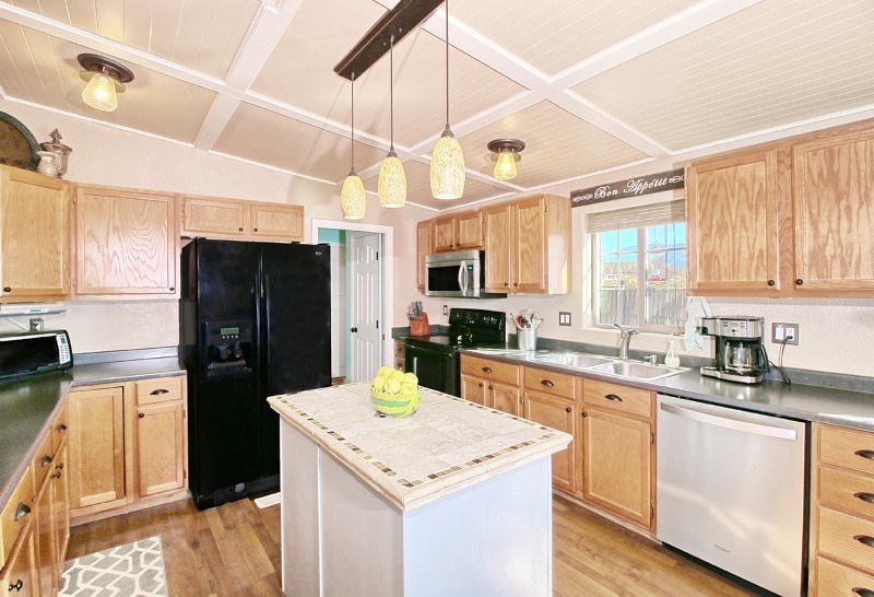 796 Siminoe Road Whitewater, CO 81527 - Photo 6 of 37 a kitchen with a sink a refrigerator a microwave and cabinets