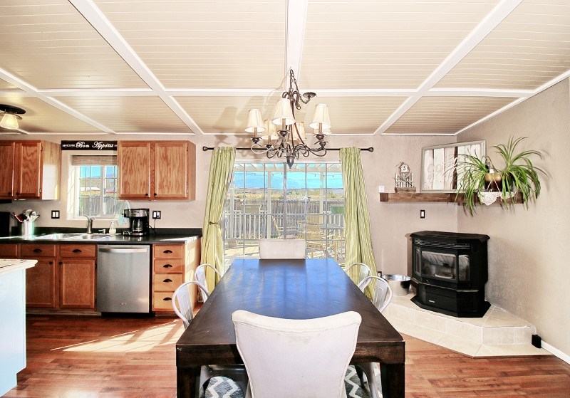 796 Siminoe Road Whitewater, CO 81527 - Photo 10 of 37 a kitchen with stainless steel appliances wooden floor dining table chairs and wooden cabinets