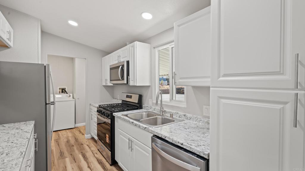 13490 Highway 8 Business, Unit 8 Lakeside, CA 92040 - Photo 7 of 29 a kitchen that has a refrigerator a sink and wooden cabinets