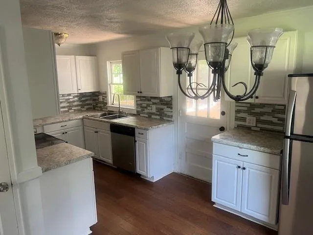a kitchen with a sink a stove and cabinets