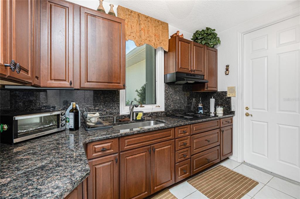 202 George Road Southeast Port Charlotte, FL 33952 - Photo 18 of 100 a kitchen with stainless steel appliances granite countertop a stove a sink and a microwave