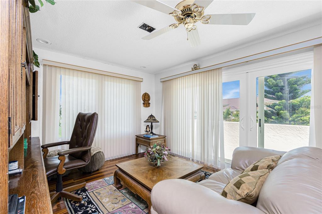 202 George Road Southeast Port Charlotte, FL 33952 - Photo 66 of 100 a living room with furniture floor to ceiling window and a flat screen tv