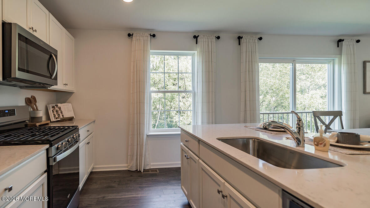 48 East 3rd Street Howell, NJ 07731 - Photo 11 of 20 a kitchen that has a sink wooden floor and a stove top oven