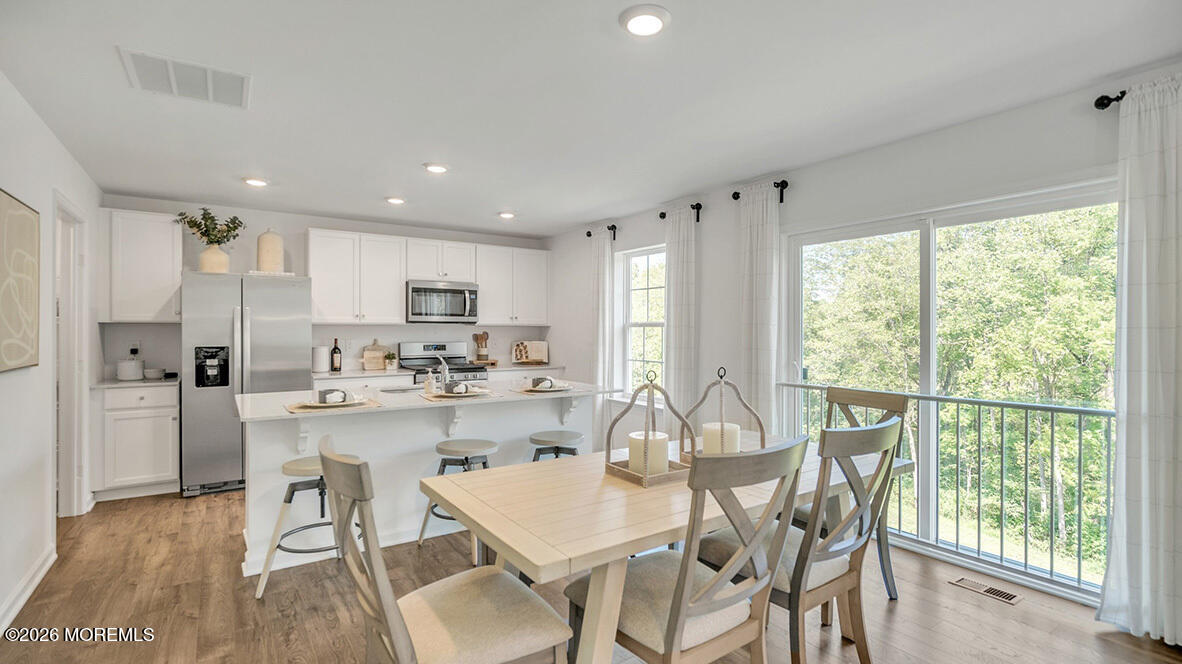 48 East 3rd Street Howell, NJ 07731 - Photo 3 of 20 a kitchen with stainless steel appliances granite countertop sink refrigerator dining table and chairs