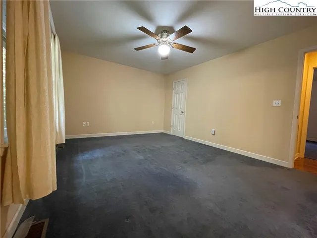 an empty room with closet and ceiling fan