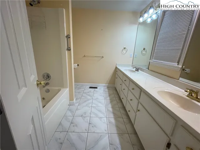 a spacious bathroom with a tub sink and mirror