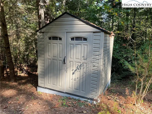 a view of a small house with backyard and garden