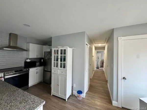 a kitchen with a refrigerator and a stove top oven