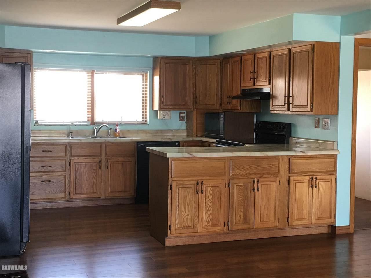 5694 Riverview Road Thomson, IL 61285 - Photo 5 of 25 a kitchen with stainless steel appliances granite countertop a stove a sink dishwasher and a microwave oven with wooden floor