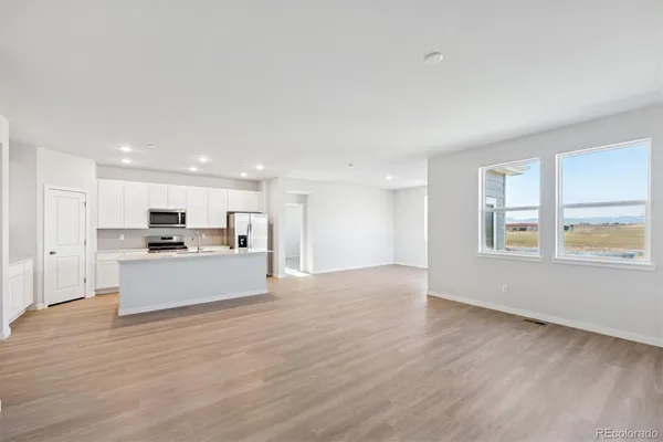 a view of kitchen with kitchen island a sink wooden floor and a stove