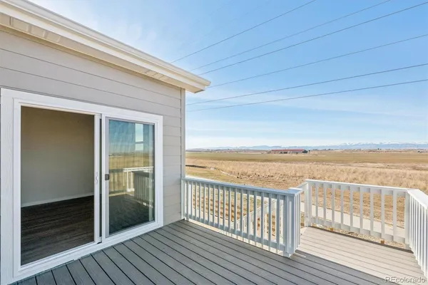 a view of a balcony with wooden floor and fence