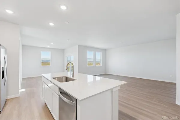 a kitchen with a sink and wooden floor