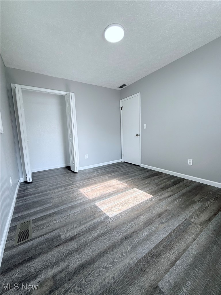 4816 Wake Robin Road Mentor, OH 44060 - Photo 12 of 19 Unfurnished bedroom with dark wood-type flooring, baseboards, and a textured ceiling