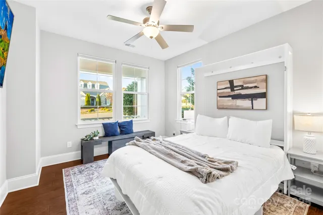 a living room with stainless steel appliances kitchen island granite countertop a stove a refrigerator a stove and white cabinets with wooden floor